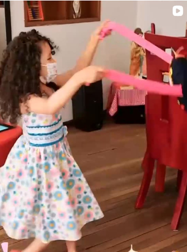 Niña bailando con cintas de colores